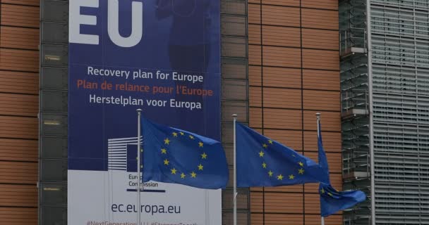 ベルギーのブリュッセル 2020年7月1日 欧州委員会の本部であるBerlaymontビルの正面にある 次世代Eu バナーの前にヨーロッパの旗 — ストック動画