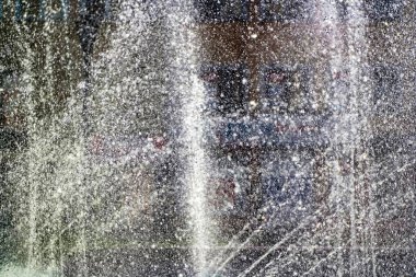 Çeşmeden fışkıran su, havaya düşen su, soyut arka plan.