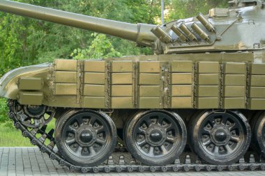 Tankın önünde, kaldırımdaki rayların yanında.