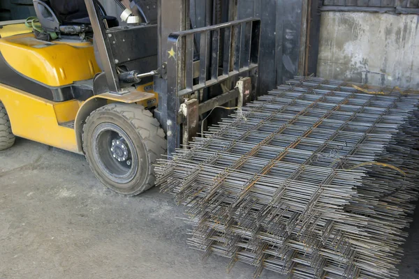 Carrello elevatore che trasporta una pila di maglie di armatura — Foto Stock