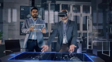 Profesyonel Erkek Otomotiv Tasarımcıları AR Kulaklık ve Şeffaf Tablet Analizi 3D Elektro Konsept Araba Modeli Giyiyor. Yüksek Teknoloji Ofisi Sanal Gerçeklik Modelleme Yazılım Uygulamasını Kullan.