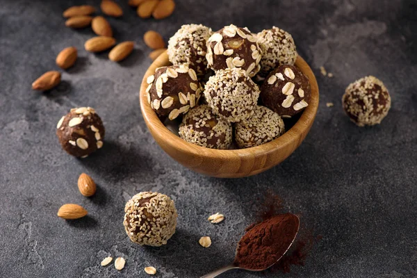 Vegan sweet bites, raw eating homemade dessert with nuts and cacao, sesam and oats