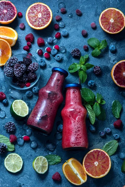 Czerwone Smoothie w butelkach z jagodami i owocami cytrusowymi, zdrowe — Zdjęcie stockowe