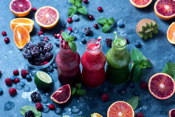 Smoothies colorés en bouteilles avec des baies et des agrumes, il — Photo