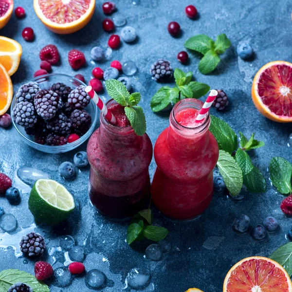 Smoothies in bottles with berries and citrus fruits, healthy vit — Stock Photo, Image