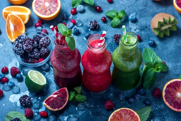 Colorful smoothies in bottles with berries and citrus fruits, he — Stock Photo, Image