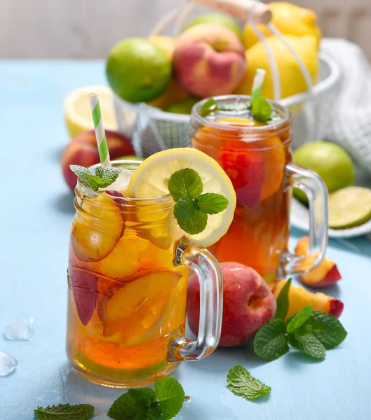 Tè freddo con pesche, limoni, lime e menta con cubetti di ghiaccio, su — Foto Stock