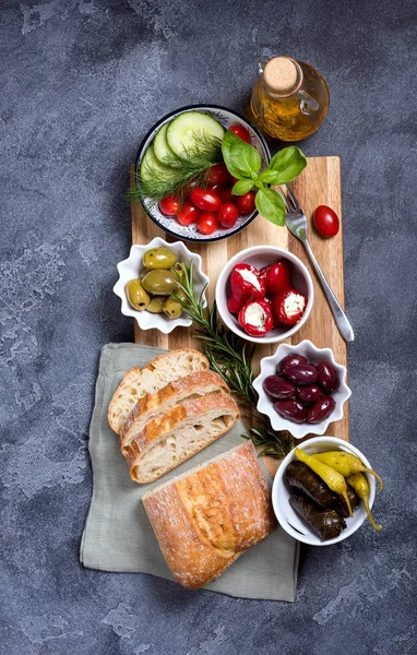 Mediterranean traditional snack with olives, pepperoni, ciabatta