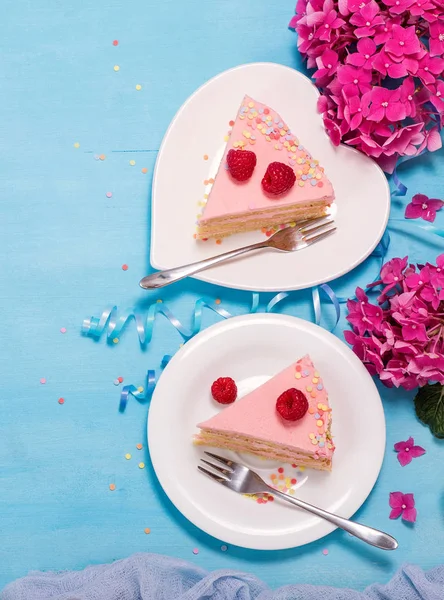 Twee stukken feestelijke taart met bloemen op blauwe achtergrond, plat — Stockfoto