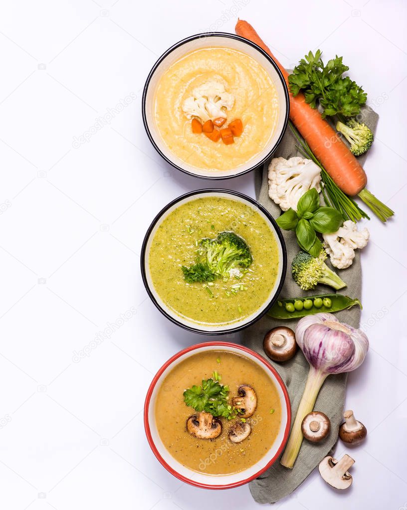 Variety of vegetable soups in bowl with ingredients, broccoli, c
