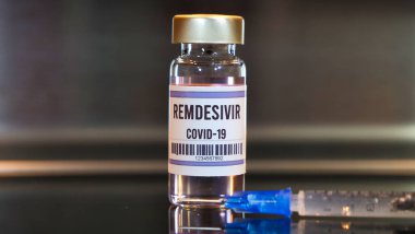 Remdesivir ilaç ve şırınga siyah masa üzerinde yansımaları ve paslanmaz arka planı ile.
