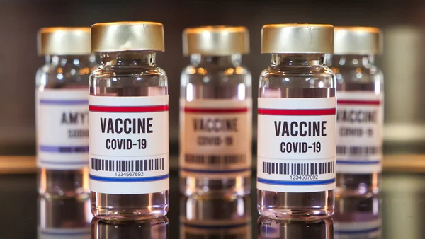Négy Kovid Vakcina Fecskendő Fekete Asztalon Visszaverődéssel Rozsdamentes Háttérrel — Stock Fotó