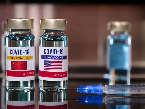 Two vials of covid-19 vaccine with labels of the flags of China and the United States USA with copy space