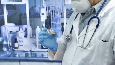 Doktor elinde bir şişe aşı anti-vax aşı aktivistleri covid-19 coronavirus tutuyor.