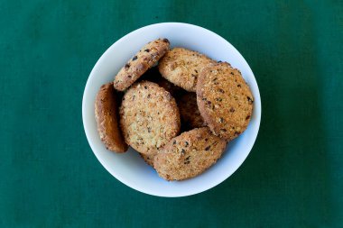 Çikolata parçalı kurabiyelerin üst görüntüsü ve yukarıdan çekimleri peçetenin üstünde, ahşap arka planda.