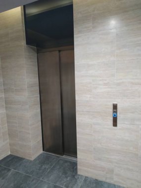 Boş modern bir asansör ya da aydınlatmalı metal kapıları olan bir asansör.