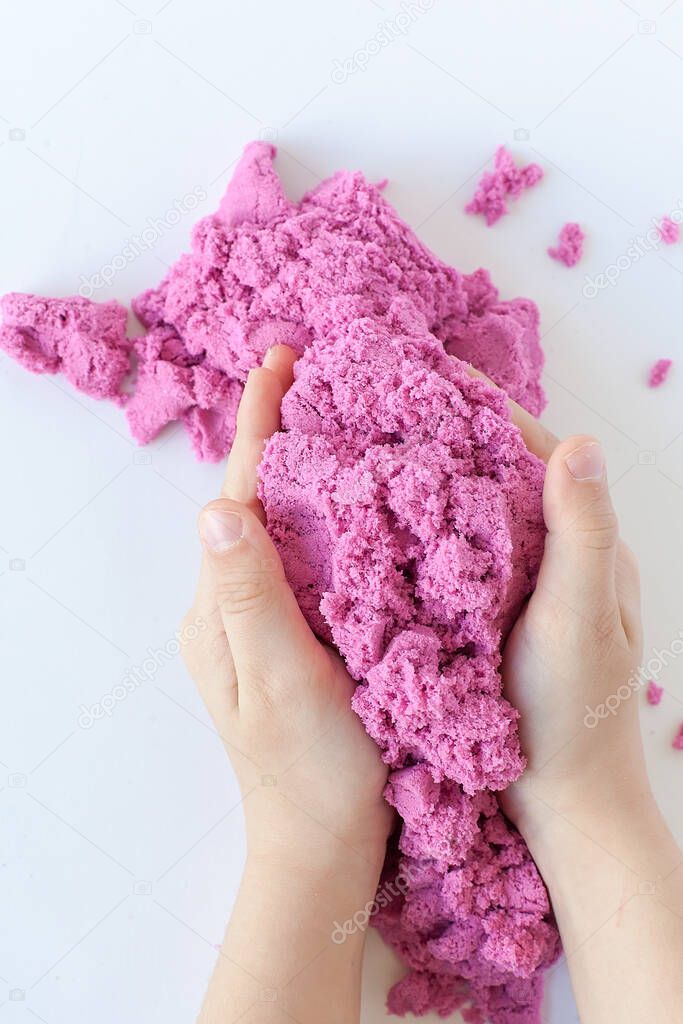 Close up of Toddler hand pressing on teal kinetic sand