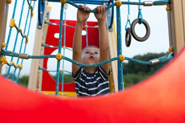 Küçük çocuk dışarıda oyun alanında eğleniyor. Çocuklar için yazın aktif spor eğlencesi. Anaokulu ya da okul bahçesi. Yürüyen çocuk aktivitesi