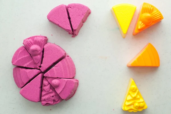 bright pink kinetic sand in the hands of a child. Development and education. Fine motor skills