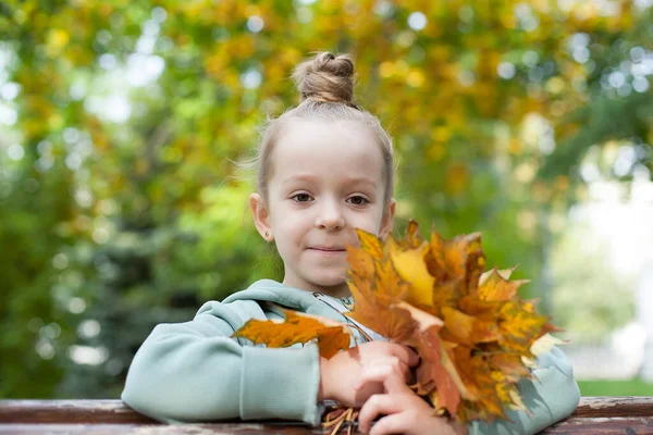 Nahaufnahme Porträt eines hübschen kleinen Mädchens, das im herbstlichen Park ruht — Stockfoto