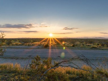 Güneş şafak vakti ıssız bir yolda yükseliyor, Hi Vista, CA.