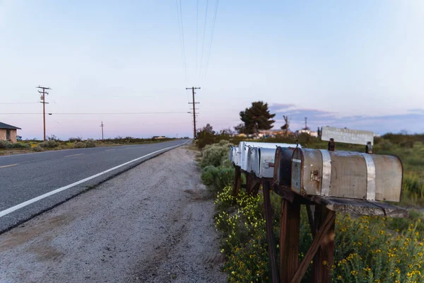 A row of empty mailboxes sit on an empty row at dawn, Hi Vista, CA.