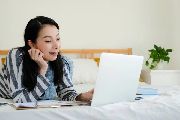 Asyalı iş kadını evde bilgisayarla çalışıyor..