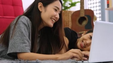 İnternette film izlemek için dizüstü bilgisayarlarını kullanan iki Asyalı kadın..