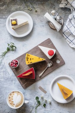 Tabaklarda çok renkli parlak tatlılar ve bir ev, bir kahve dükkanının yaz menüsü, bir sürü farklı kek.