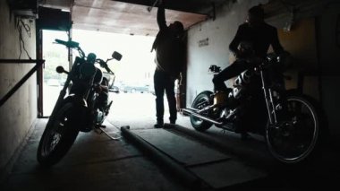 İki bisikletçileri özel motosiklet garajdan alarak