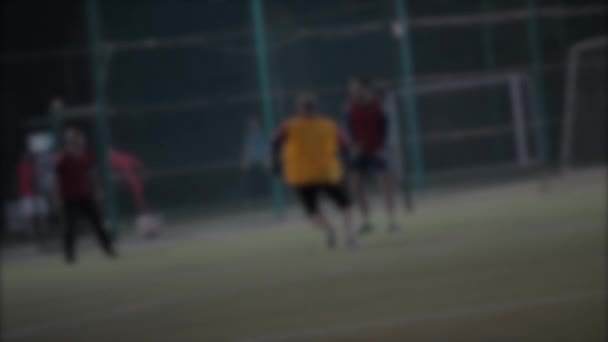 Borroso de hombres jugando al fútbol al aire libre en la noche . — Vídeos de Stock