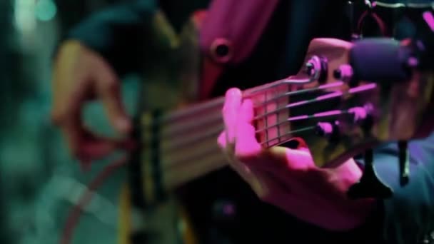 Чоловік бас-гітарист грає на електрогітарі — стокове відео