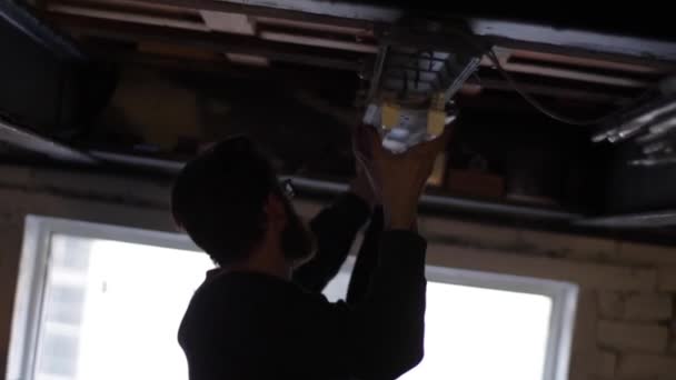 Elektrikçi tavandaki neonu tamir ediyor. — Stok video
