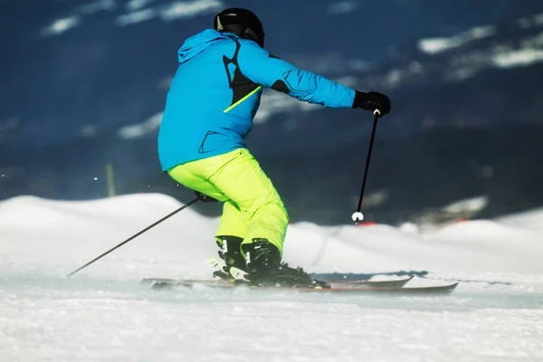 青いジャケットの黄色スパイク スキーヤー下降ドロミテの斜面に動的に — ストック写真