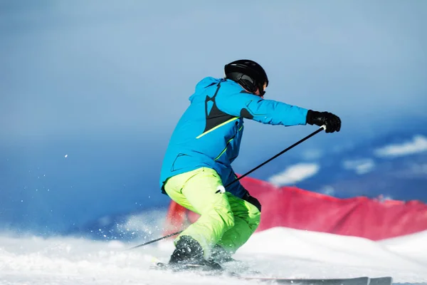 在白云岩斜坡上 蓝色夹克和黄色穗面的滑雪者动态下降 — 图库照片
