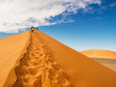 Dune tuz tavada Sossusvlei alan Namib Çölü Namibya'nın 45. Dune Sossusvlei tuz havzası içinde üstündeki insanlar.