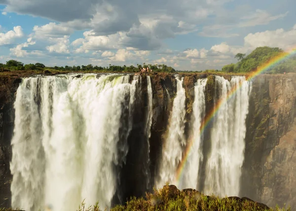 Rainbow over Victoria Falls on Zambezi River. Victoria falls is a waterfall in southern Africa on the Zambezi River at the border of Zambia and Zimbabwe.