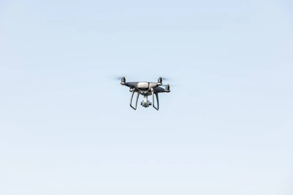 Desembarcar uma mão com hélices giratórias. Drone voador no céu azul . — Fotografia de Stock
