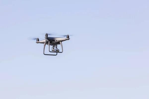 Desembarcar uma mão com hélices giratórias. Drone voador no céu azul . — Fotografia de Stock