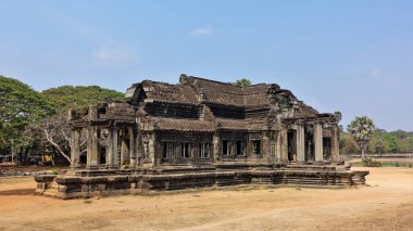 Angkor Wat kütüphane binası. Güneşli bir yaz günü. Antik bir taşın kalıntıları eşsiz bir haç biçimindeki bina. Girişlerde, pencerelerde ve çatıda iyi korunmuş sütunlar var. UNESCO Mirası. Kamboçya.