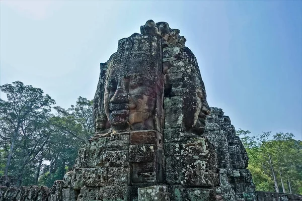 Dziwne Posągi Szczycie Świątyni Czystym Niebie Ogromne Ludzkie Twarze Patrzą — Zdjęcie stockowe