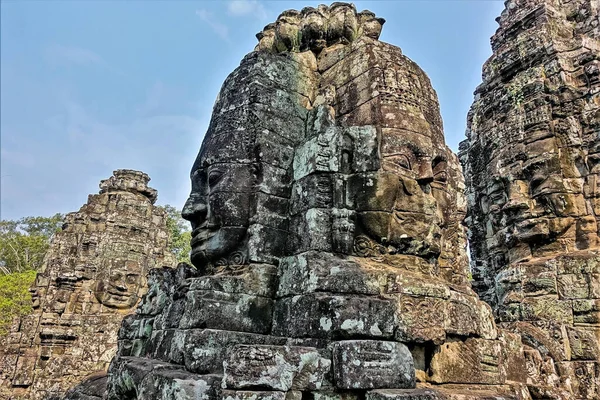 バイヨンの古代の神秘的な寺院 石から刻まれた巨大な人間の顔は すべての方向を見ている 彼らの顔に奇妙な笑顔 過ぎ去った文明の謎 カンボジア アンコール — ストック写真