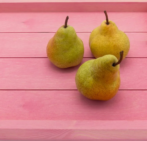 Três Peras Amarelas Maduras Estão Uma Bandeja Madeira Rosa Manchas — Fotografia de Stock