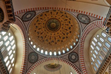 Cami 'nin iç dekorasyonunun ayrıntıları. Yüksek kubbe kırmızı ve altın süslemelerle süslenmiş. Kemerli mahzenlerdeki kafes camları. İstanbul, Türkiye.