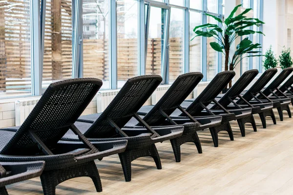 A row of black sun loungers in a spa center