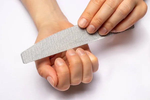 Manicure at home, sawing nails with a sawn-off and giving a square shape to the nail plate. Caring nails.