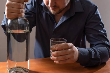 Bir adam ve bir bardak votka. Alkolizm, alkol bağımlılığı.
