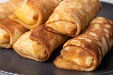 Siyah arka plana doldurulmuş krepler. Ev yapımı hamur işleri, glütensiz ve buğday unu.