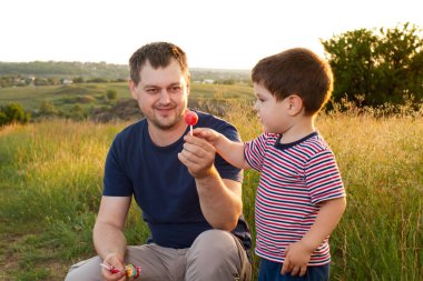 Baba ve oğlu akşamları sarı bir yaz tarlasında yürürler ve çubuk üzerinde şeker yerler. Babalar Günü, ailede sevgi, çocuk yetiştirmede babanın rolü.