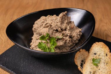 Bir tabak sığır ciğeri ve siyah tabakta sebzeli et ve çıtır tost. Restoran yemekleri.